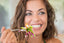 smiling woman eating a salad
