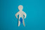 paper cut out of person showing groin sweat on blue background