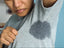 woman with grey tshirt sweating who needs prescription antiperspirant